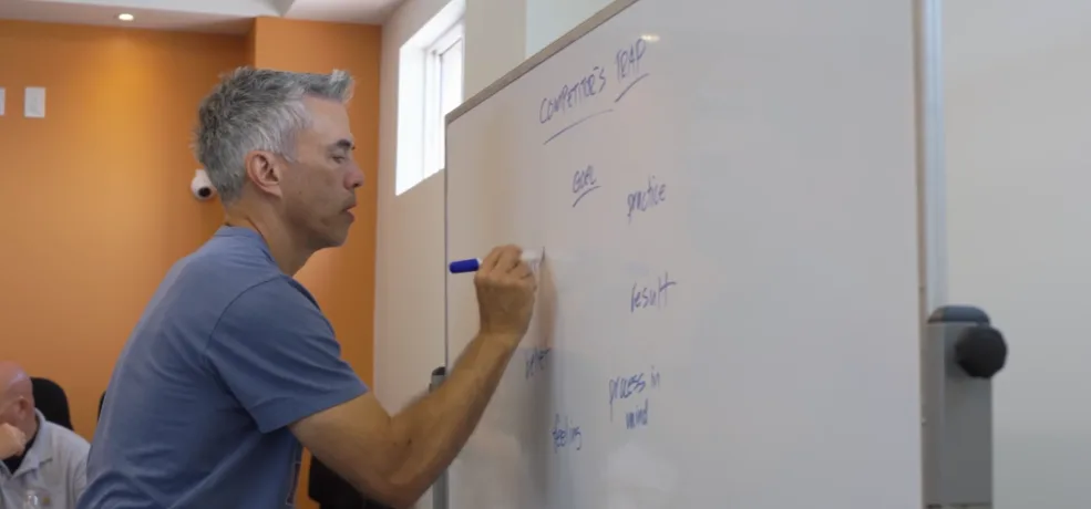 Jim Murphy coaching at a whiteboard during a retreat session