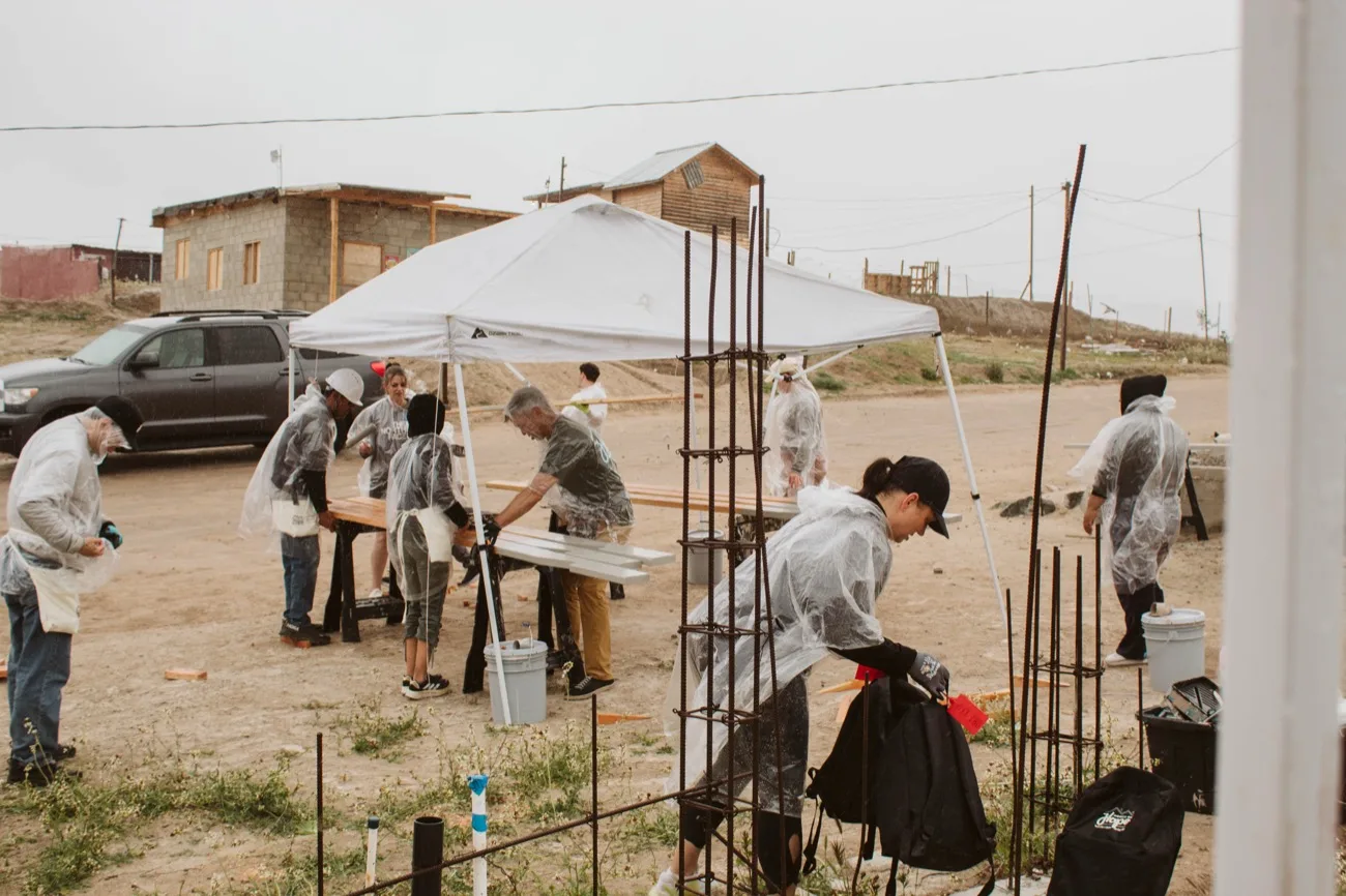 Volunteers gathered around the foundation of a new home
