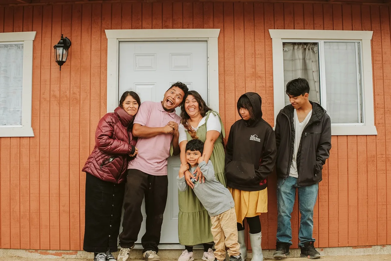 A family outside their finished home