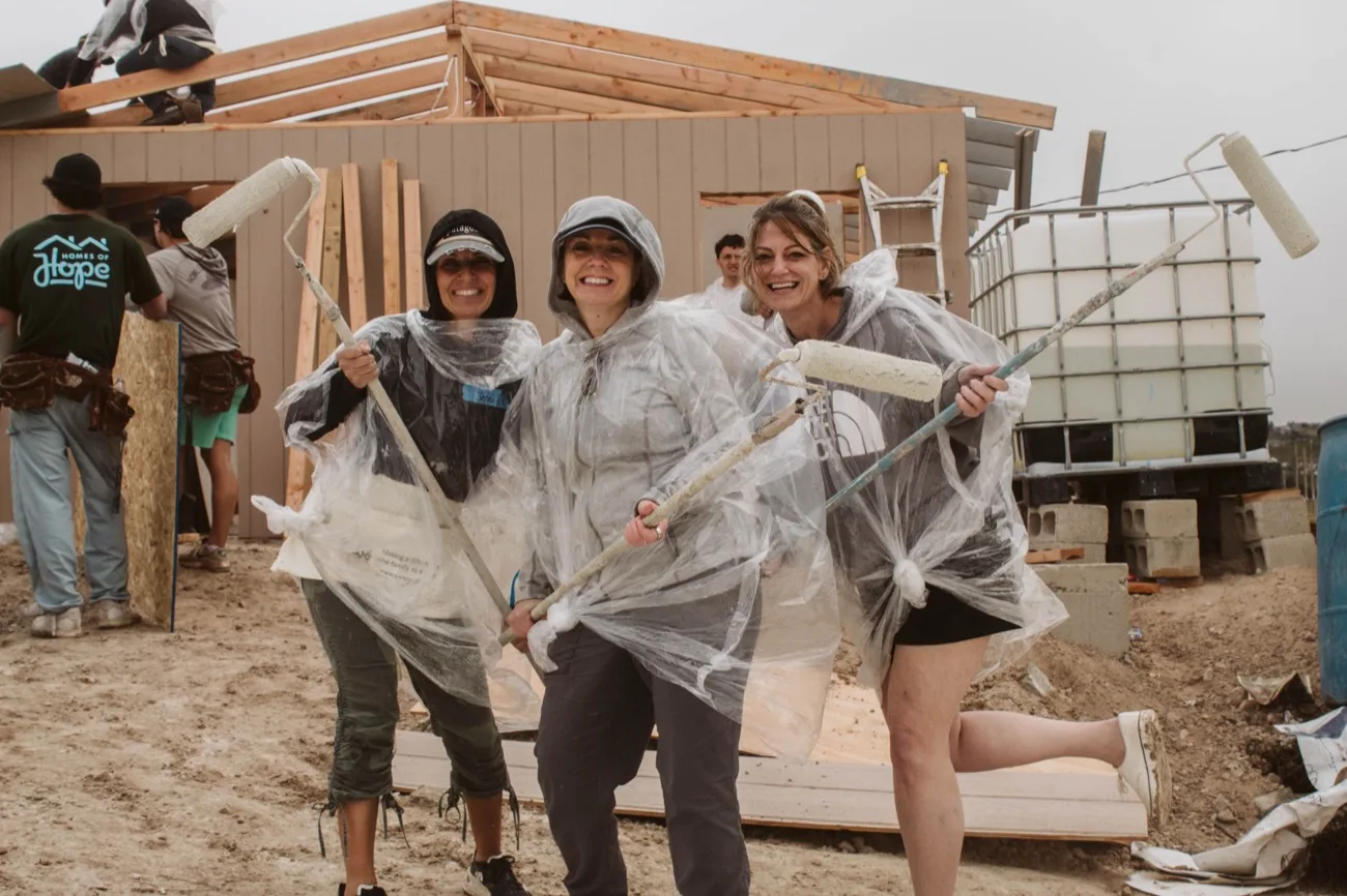 Volunteers painting in the rain